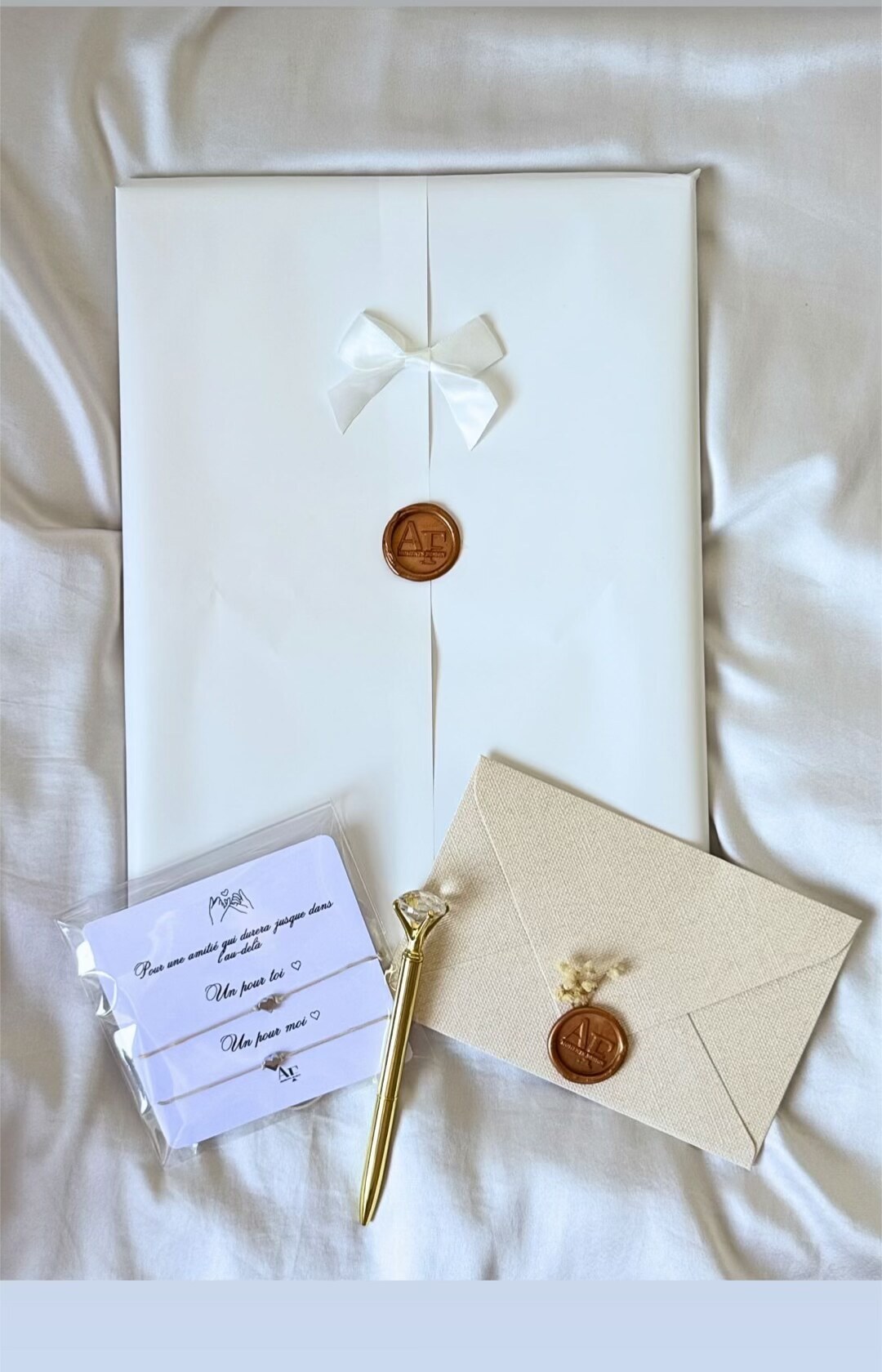 Emballage blanc, bracelets et stylo doré